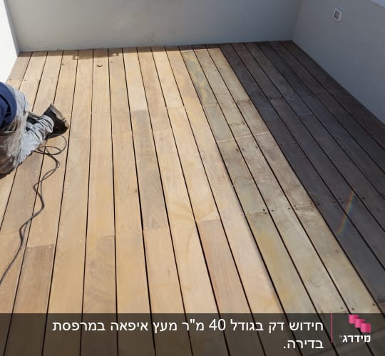 אדם עובד על רצפת עץ עם כבל חשמלי